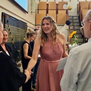 MTR-Absolventin nimmt Zeugnis entgegen und schüttelt erfreut die Hand ihrer Lehrerin