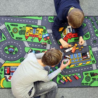 Das Bild zeigt spielende Kinder auf einem Spielteppich