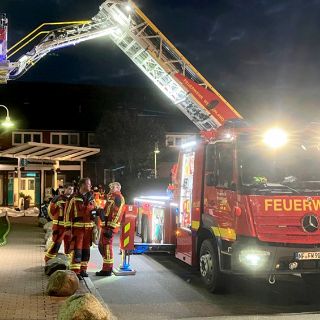 Das Motiv zeigt ein Feuerwehrauto mit Drehleiter bei einer Übung an der Nordseeklinik.